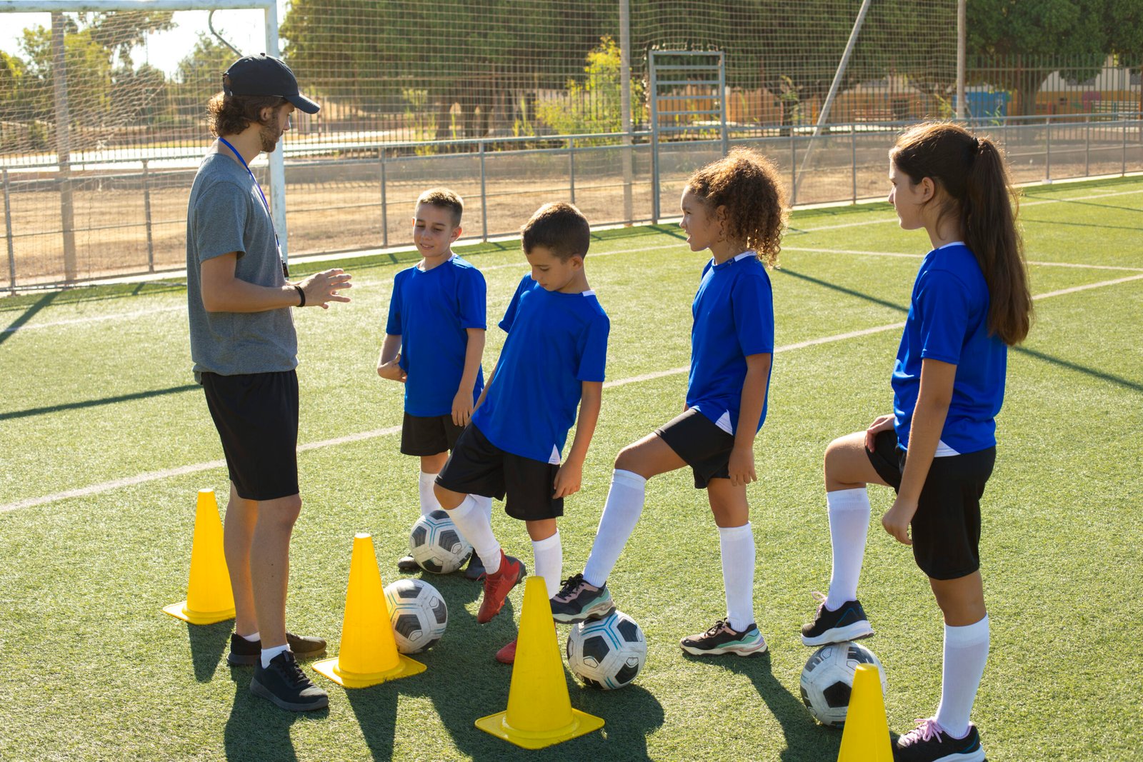 full shot man training kids playing football
