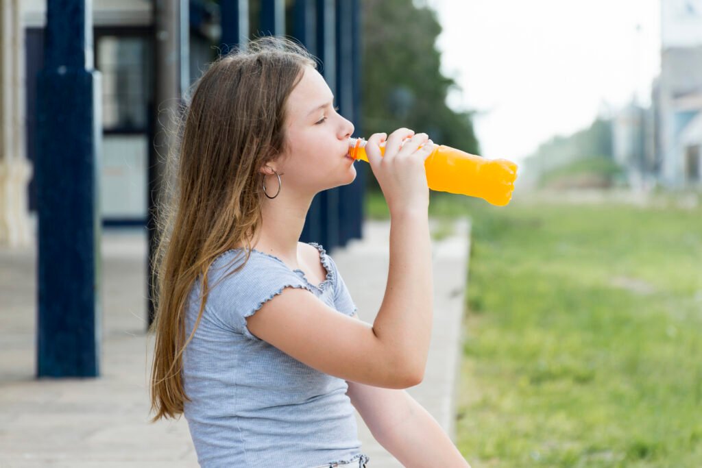 side view beautiful teenage girl drinking juice park
